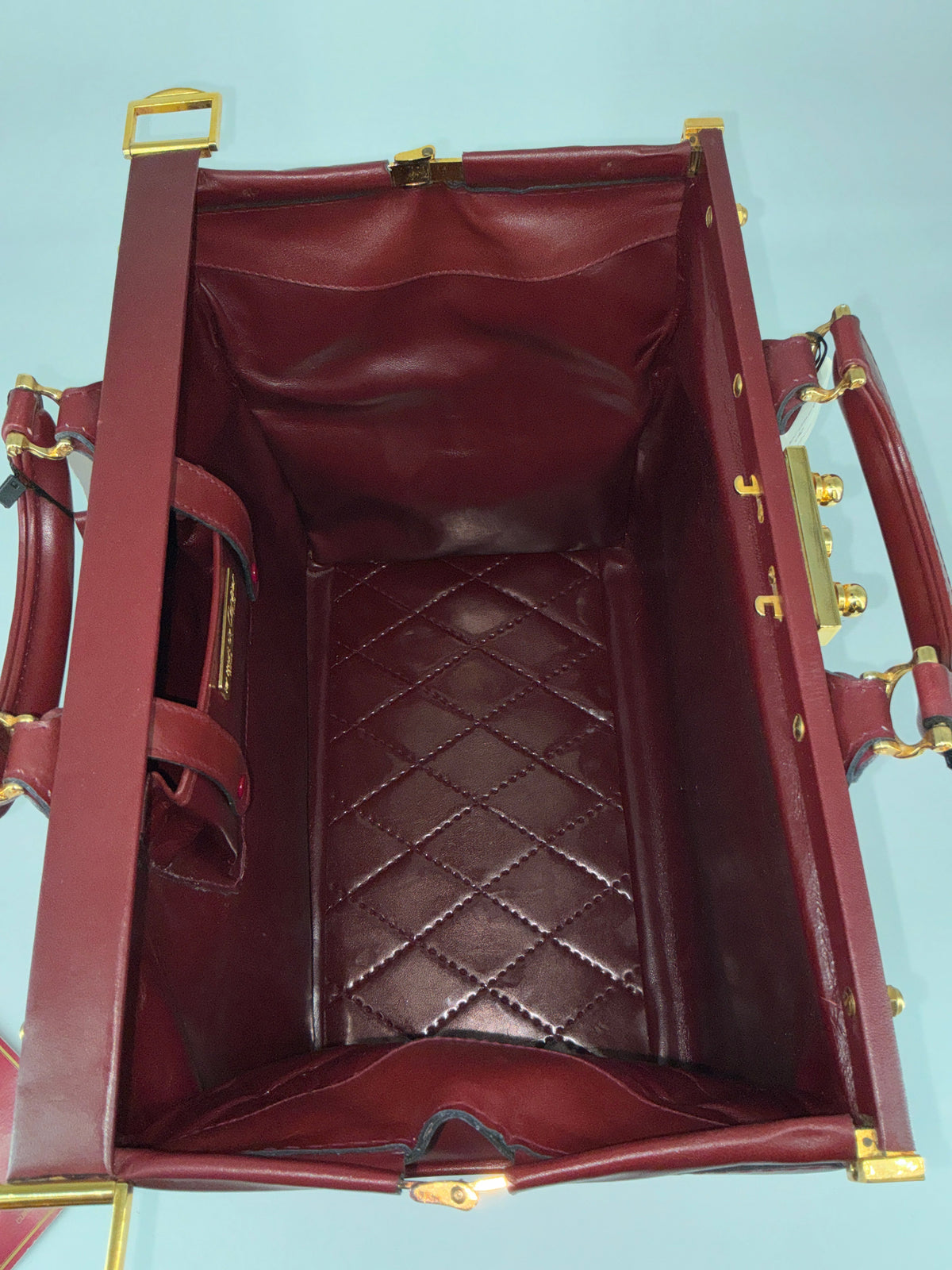 House of Melton vintage Les Must de Cartier bordeaux suede doctor bag interior with quilted base and gold hardware