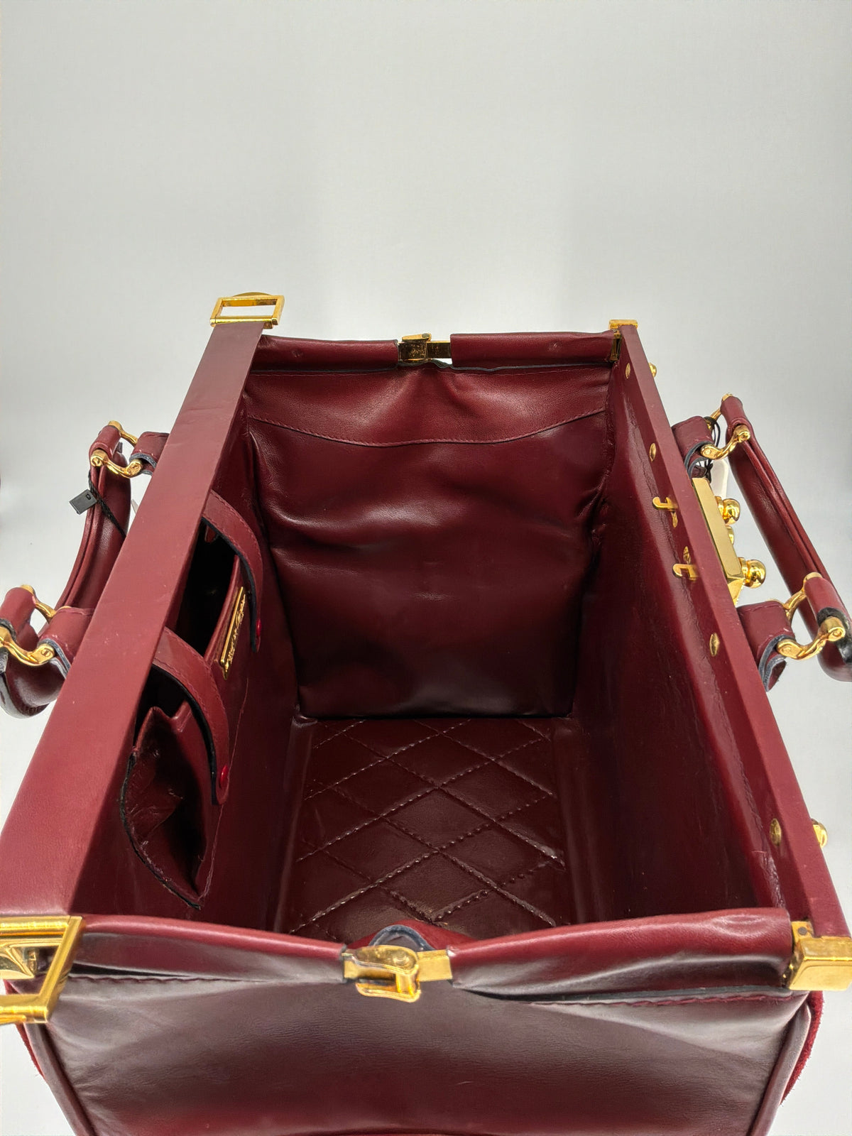 House of Melton vintage Les Must de Cartier bordeaux suede doctor bag interior with quilted base and gold hardware